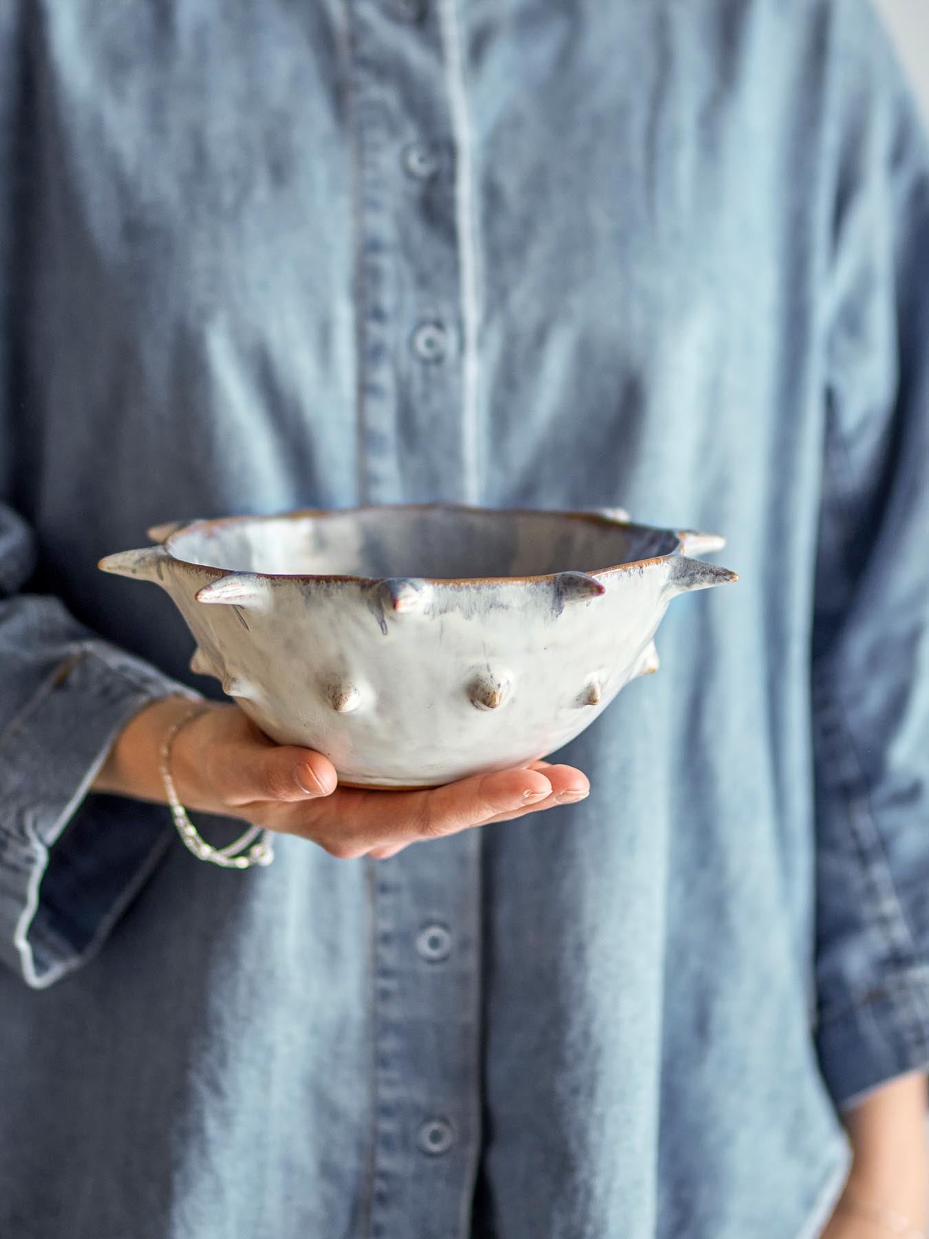 Entdecken Sie die Edie Schale von Bloomingville – ein einzigartiges, handgefertigtes Stück aus robustem Steinzeug mit faszinierender, reaktiver Glasur in Blau- und Grautönen.