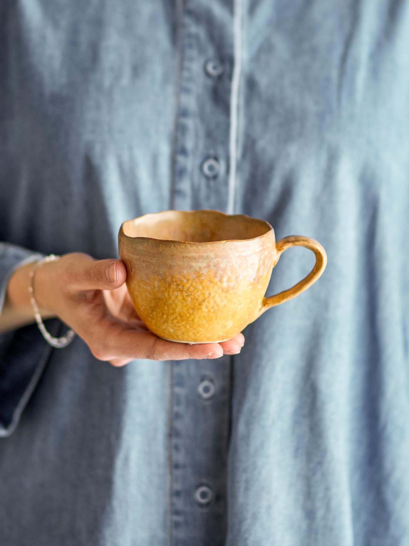 Genießen Sie Ihren Kaffee stilvoll mit der Milani Tasse von Bloomingville. Diese gelbe Steinguttasse ist ein einzigartiges Kunstwerk für jeden Anlass.