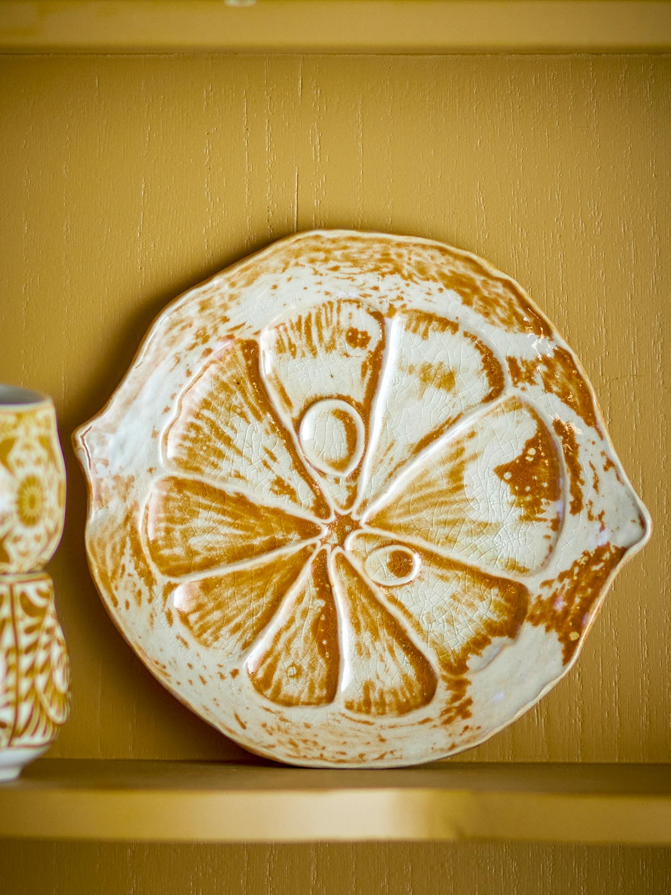 Verleihen Sie Ihrer Tischdekoration mit der einzigartigen Golda Servierplatte in Zitronenform aus robustem Steinzeug einen Hauch von Eleganz.