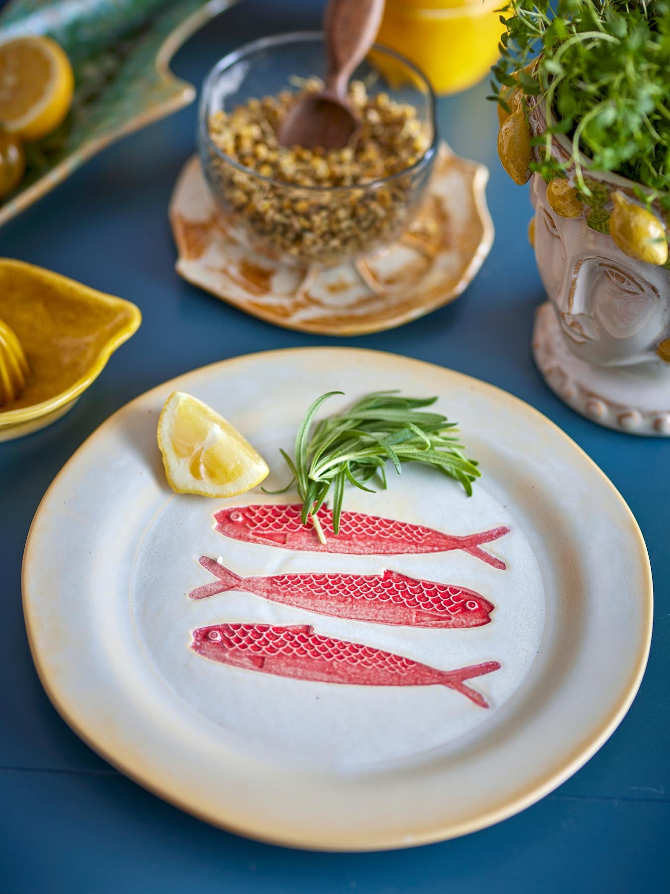 Erleben Sie den Hadden Teller in Rot von Creative Collection – ein elegantes Steingut-Set mit charmantem Fischdesign, perfekt für festliche Tische.