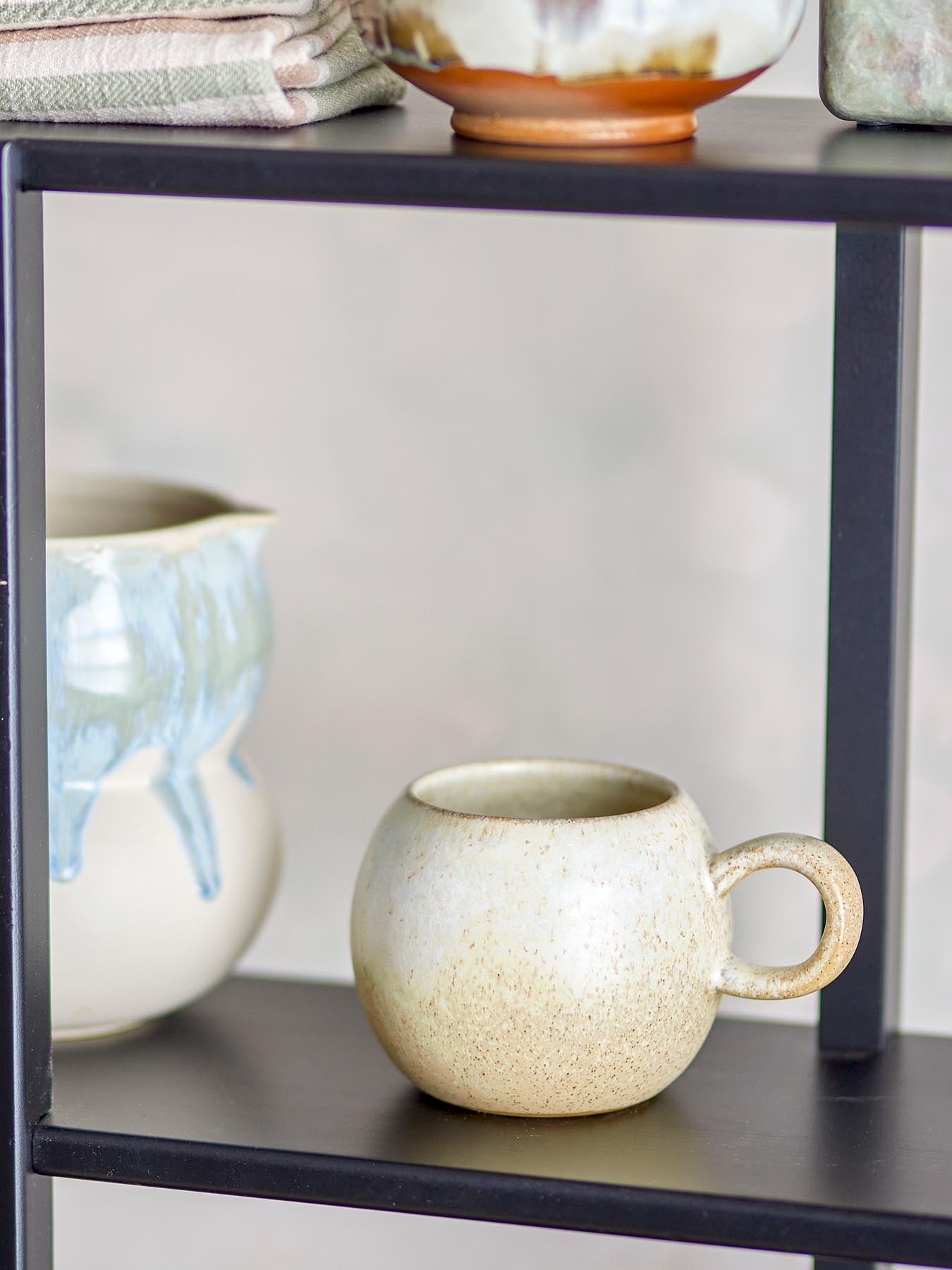 Entdecken Sie den einzigartigen Paula Becher aus Steingut von Bloomingville. Mit seiner warmen, sandfarbenen Glasur und ergonomischem Design ist er ideal für jeden Genuss.