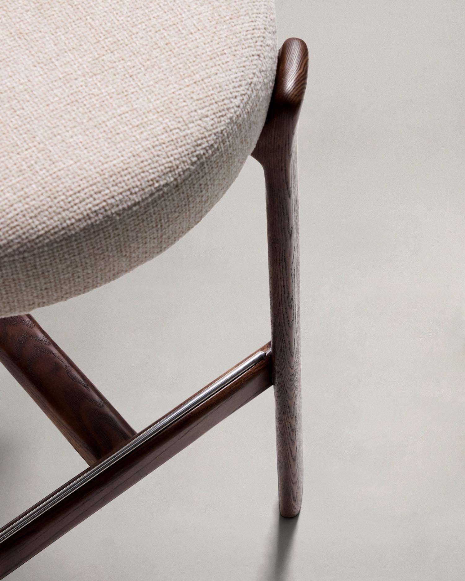 Erleben Sie den Hocker Granite von Kave Home: Beigefarbene Chenille und massives Eschenholz vereinen sich in stilvollem skandinavischen Design.