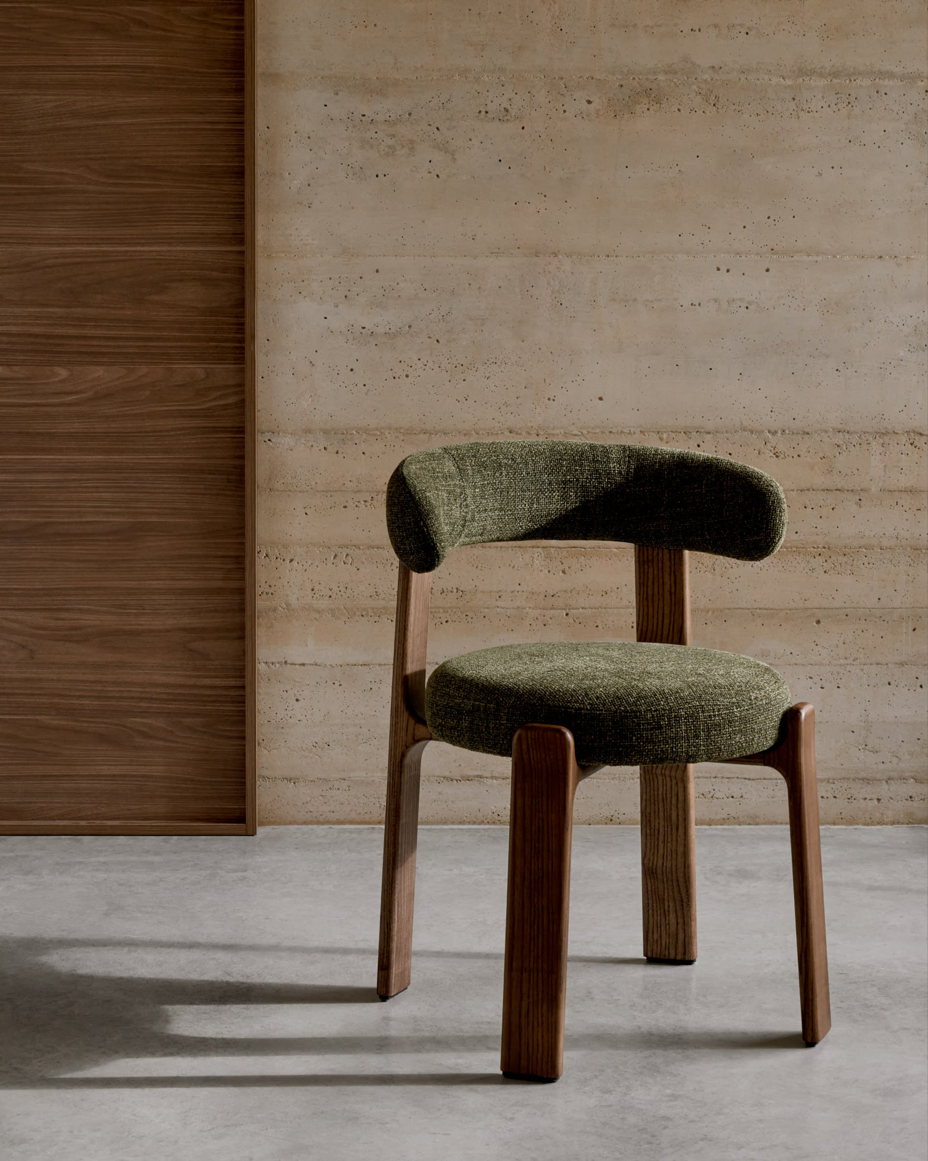 Moderner Stuhl aus grüner Chenille und FSC-zertifiziertem Eschenholz mit Walnuss-Finish, stilvoll und nachhaltig.