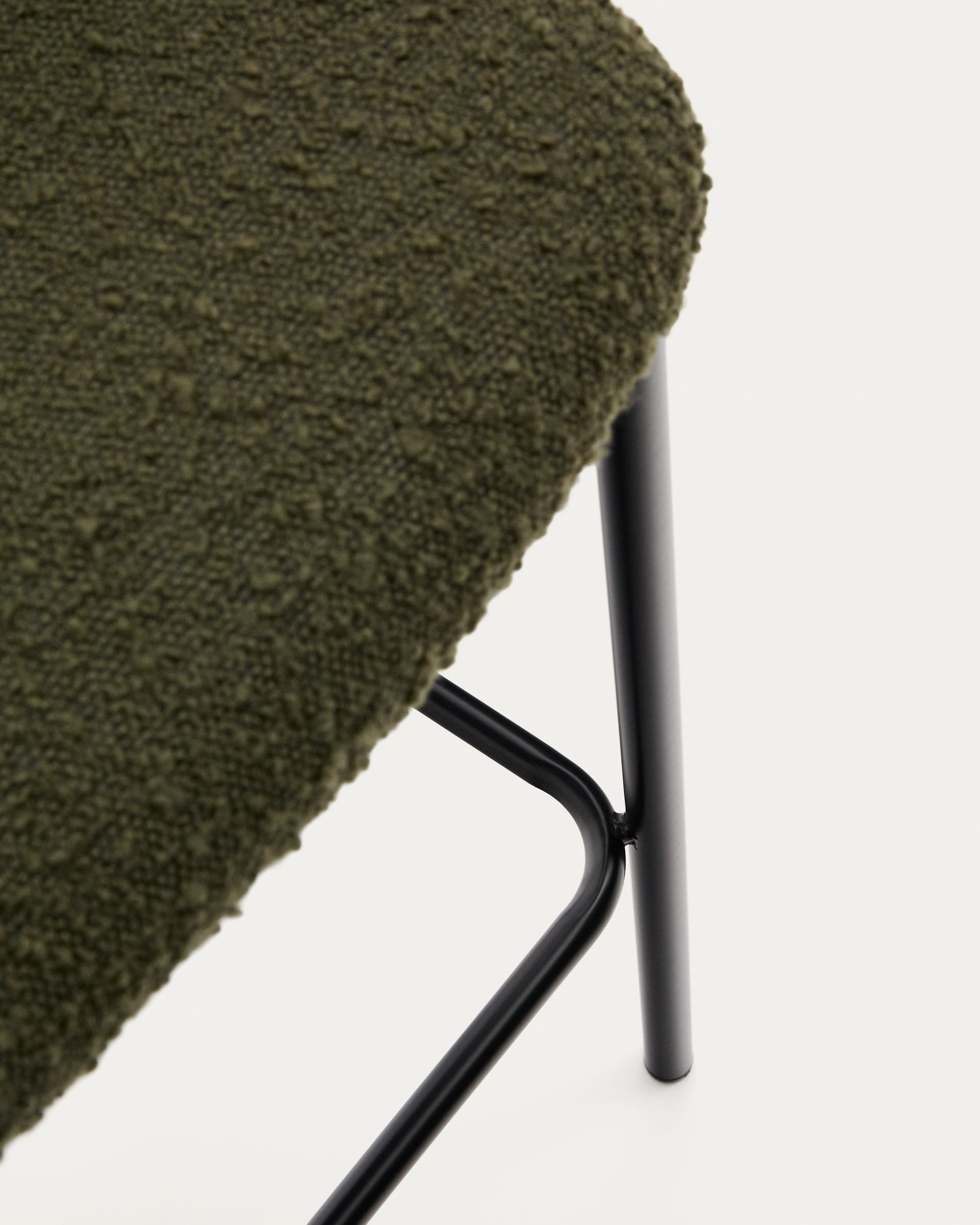 Entdecken Sie den Hocker Ciselia: Luxuriöses grünes Schaffell trifft auf robusten schwarzen Stahl. Ideal für moderne Wohnräume, 65 cm hoch.