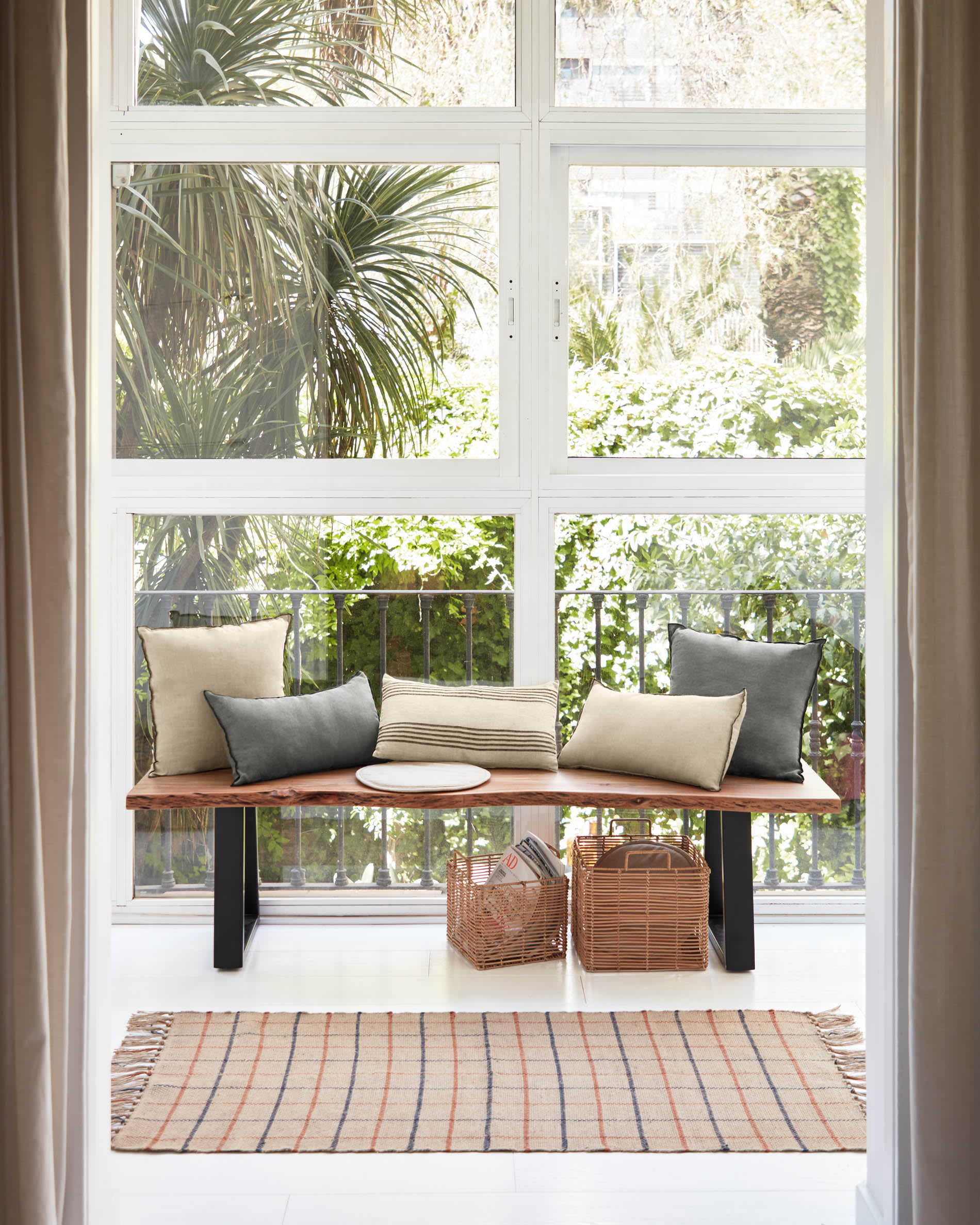 Die Alaia Bank von Kave Home vereint elegantes Design aus Akazienholz und schwarzem Stahl, ideal für stilvolle Wohnräume.