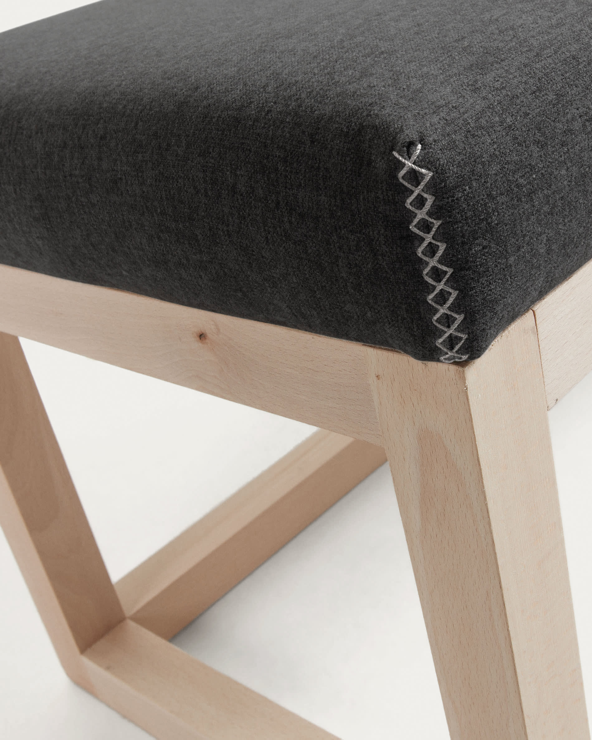 Elegante Polsterbank Loya in Schwarz, 128 cm, aus massivem Buchenholz. Ideal für stilvolle Räume und hohen Sitzkomfort.