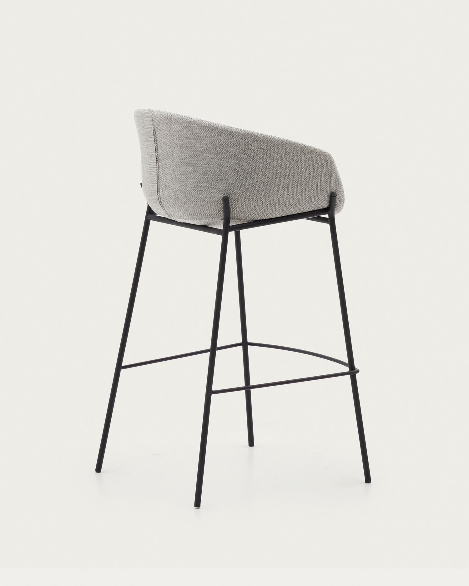 Moderner Hocker Yvette mit hellgrauem Sitz und stabilen schwarzen Stahlbeinen, 75 cm hoch, ideal für stilvolle Einrichtungen.