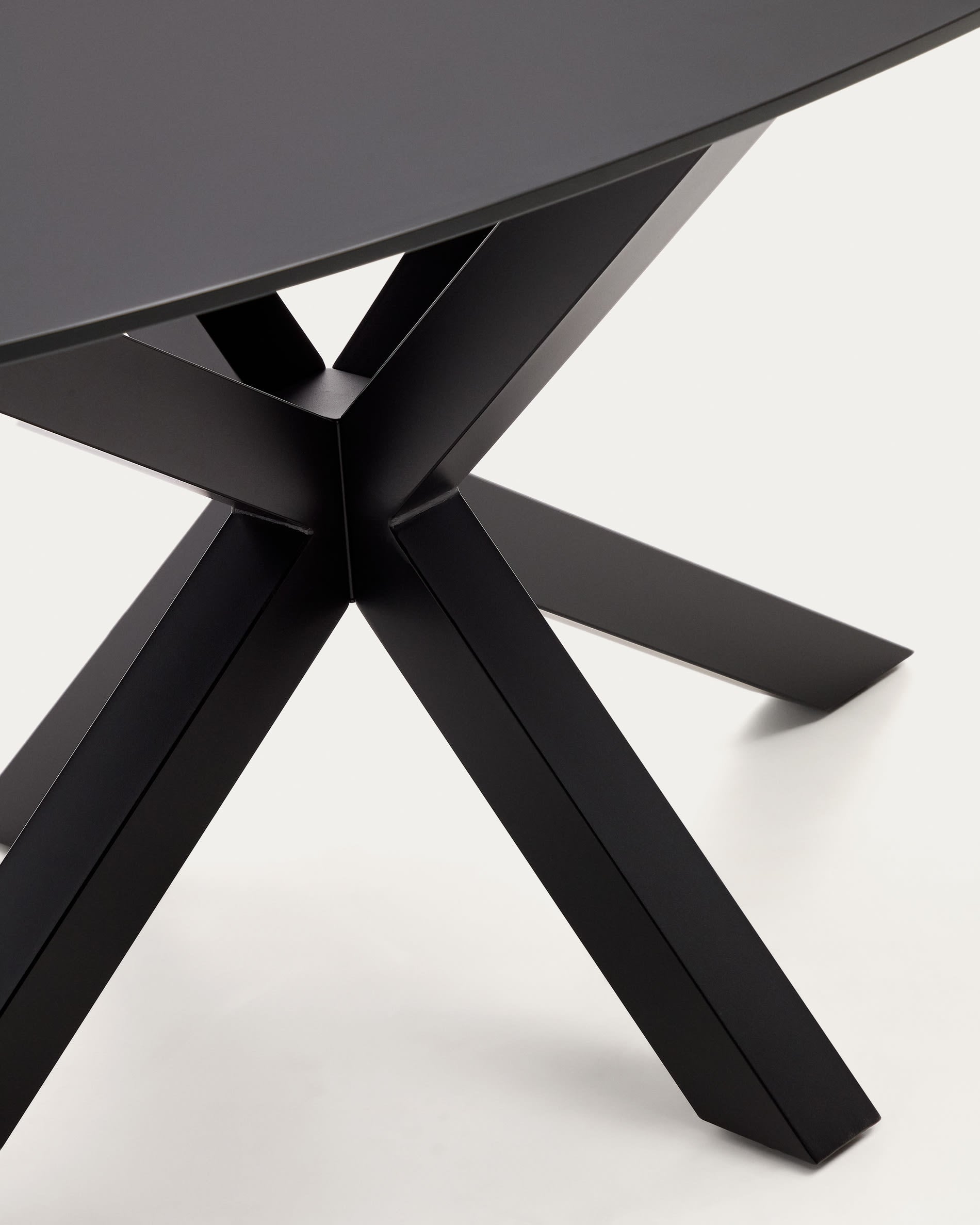 Eleganter Argo Tisch von Kave Home: Transparente Glasoberfläche, stabile schwarze Stahlbeine, Ø 200 x 100 cm, ideal für stilvolle Zusammenkünfte.