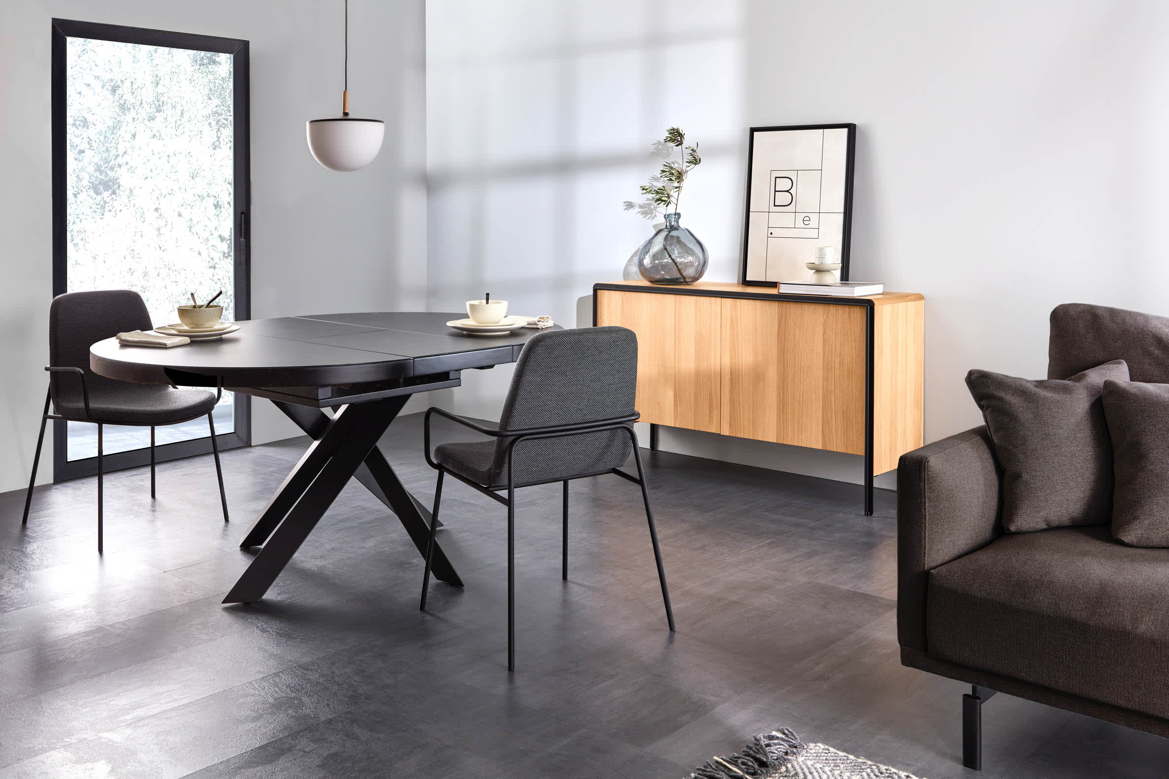 Moderner runder Ausziehtisch mit Glasplatte und schwarzen Stahlbeinen, Ø 120-160 cm, ideal für stilvolle Esszimmer.