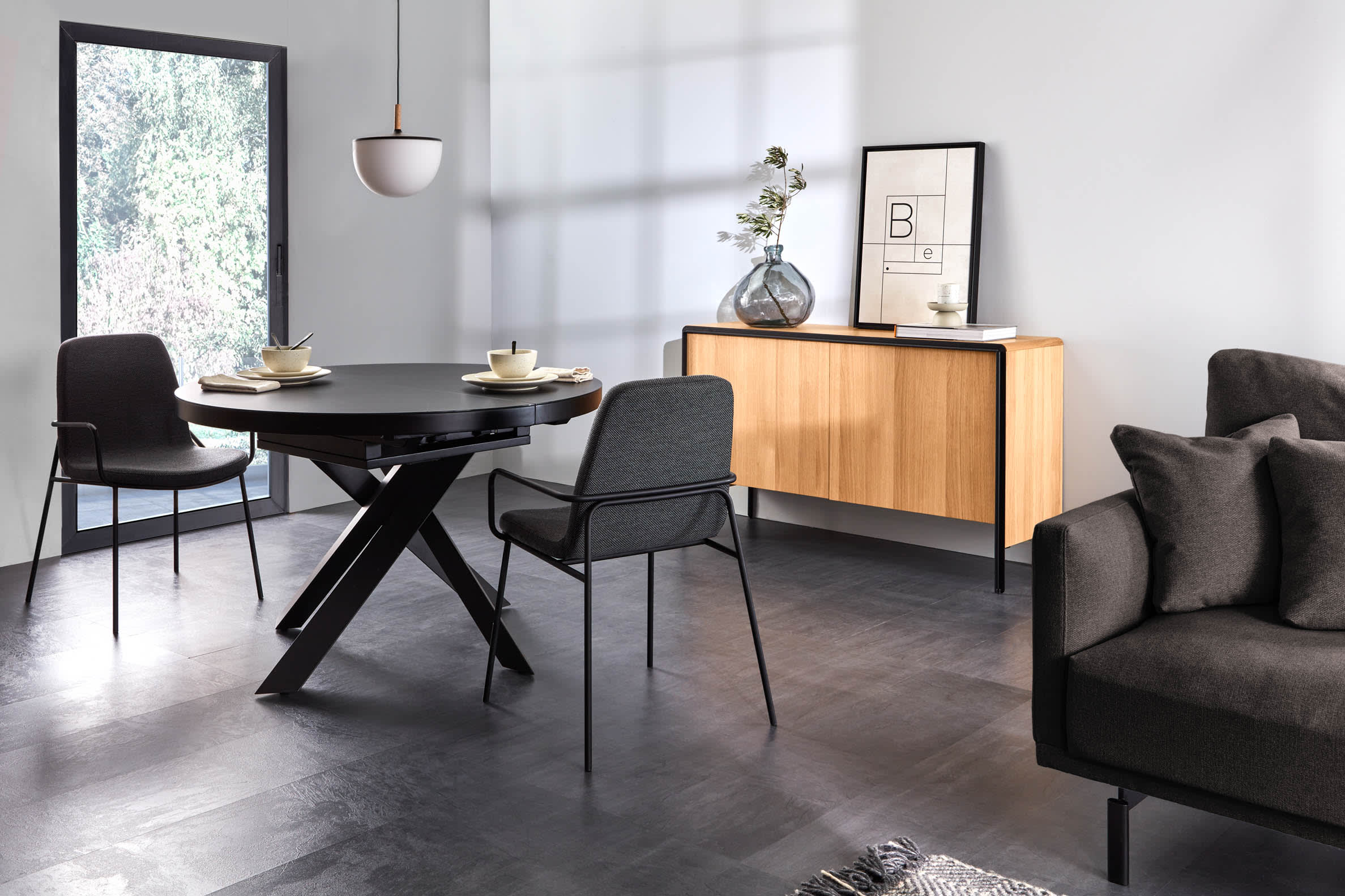 Eleganter runder Ausziehtisch mit Glasplatte und schwarzen Stahlbeinen, Ø 120-160 cm, perfekt für moderne Wohnräume.