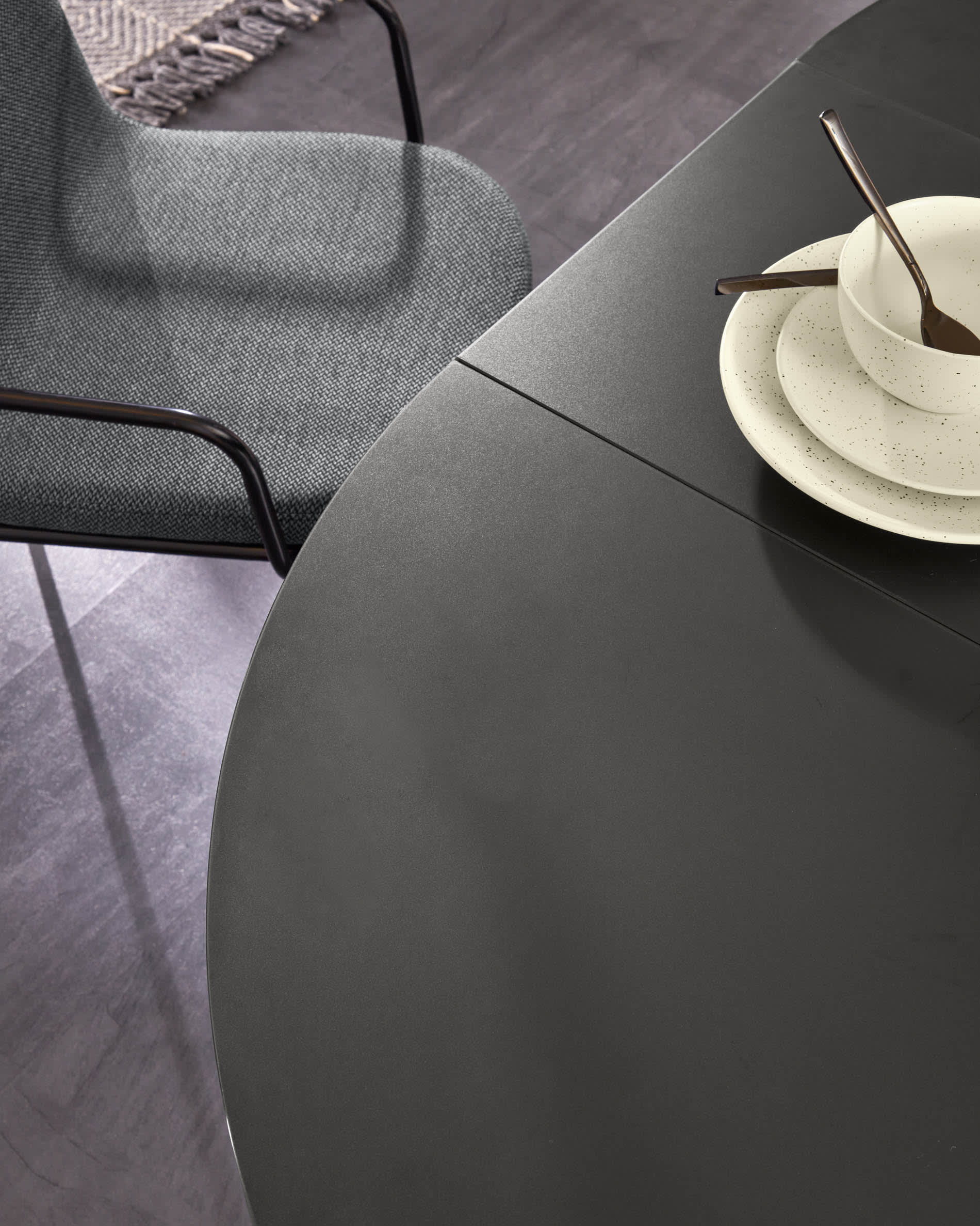 Moderner runder Ausziehtisch mit Glasplatte und schwarzen Stahlbeinen, Ø 120-160 cm, ideal für stilvolle Esszimmer.