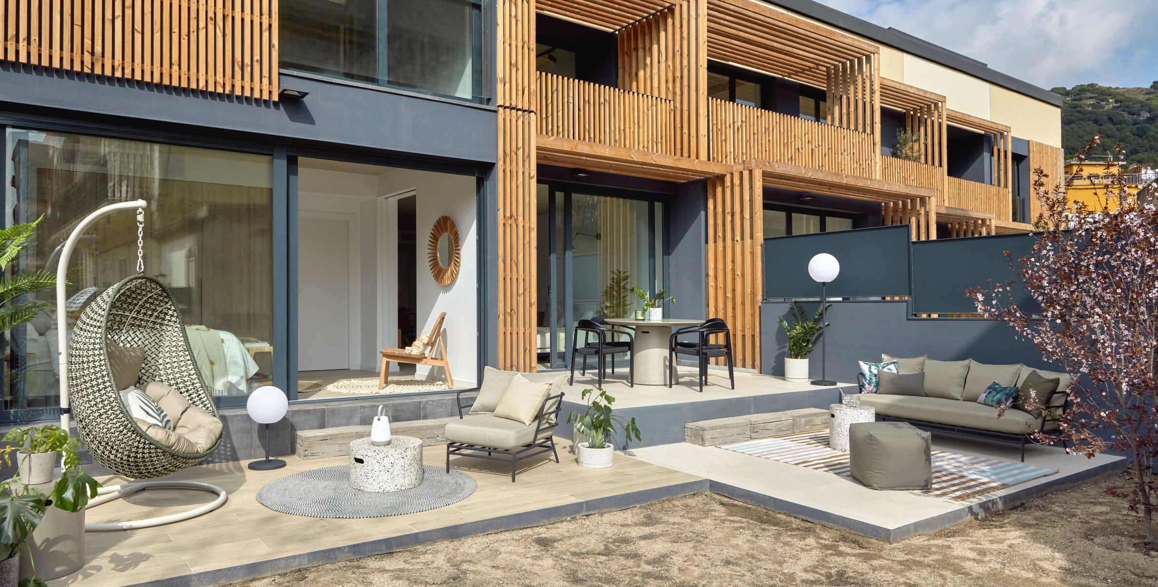 Der Hängesessel Cira vereint Stil und Komfort mit einem stabilen hellgrauen Standfuss und mehrfarbigem Design.