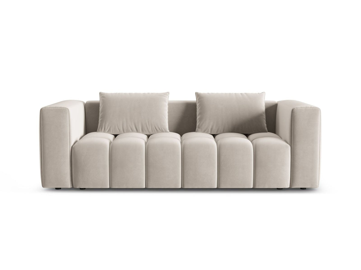 Sandfarbenes Samt-Bettsofa Verona mit drei Sitzplätzen, ausklappbarer Liegefläche, Bettkasten und schwarzen Kunststoffbeinen im Wohnraum.
