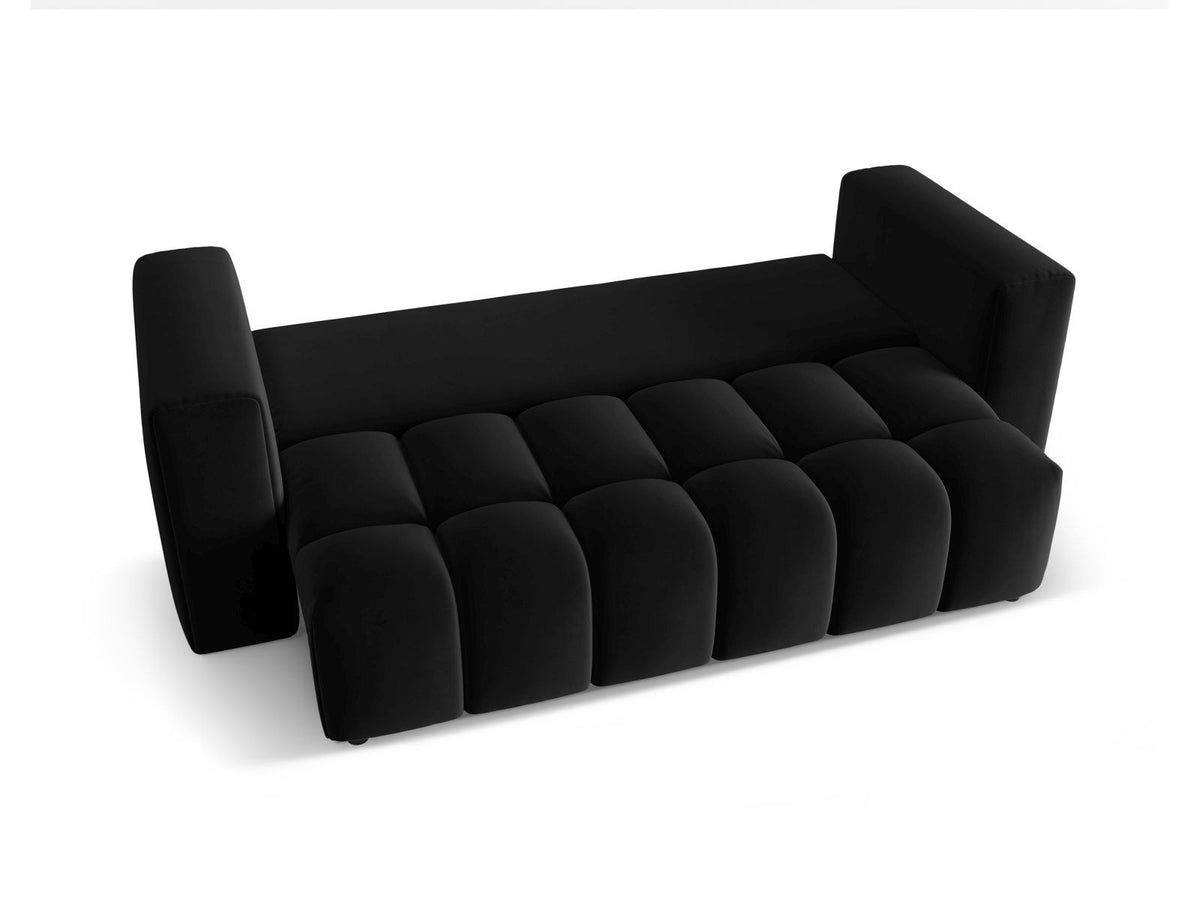 Sandfarbenes Samt-Bettsofa Verona mit drei Sitzplätzen, ausklappbarer Liegefläche, Bettkasten und schwarzen Kunststoffbeinen im Wohnraum.