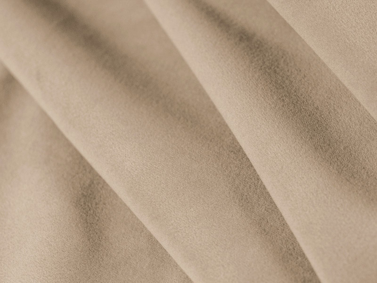 Sandfarbenes Samt-Bettsofa Verona mit drei Sitzplätzen, ausklappbarer Liegefläche, Bettkasten und schwarzen Kunststoffbeinen im Wohnraum.