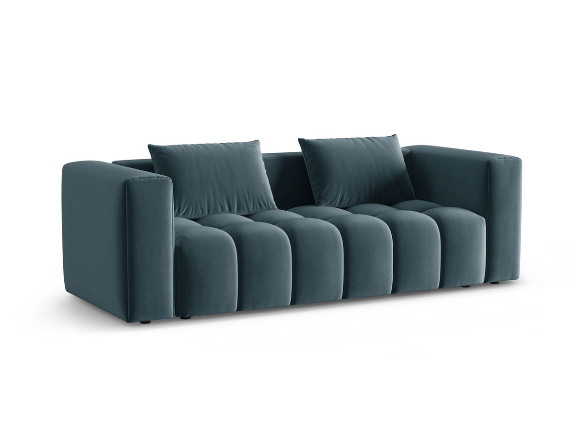 Sandfarbenes Samt-Bettsofa Verona mit drei Sitzplätzen, ausklappbarer Liegefläche, Bettkasten und schwarzen Kunststoffbeinen im Wohnraum.