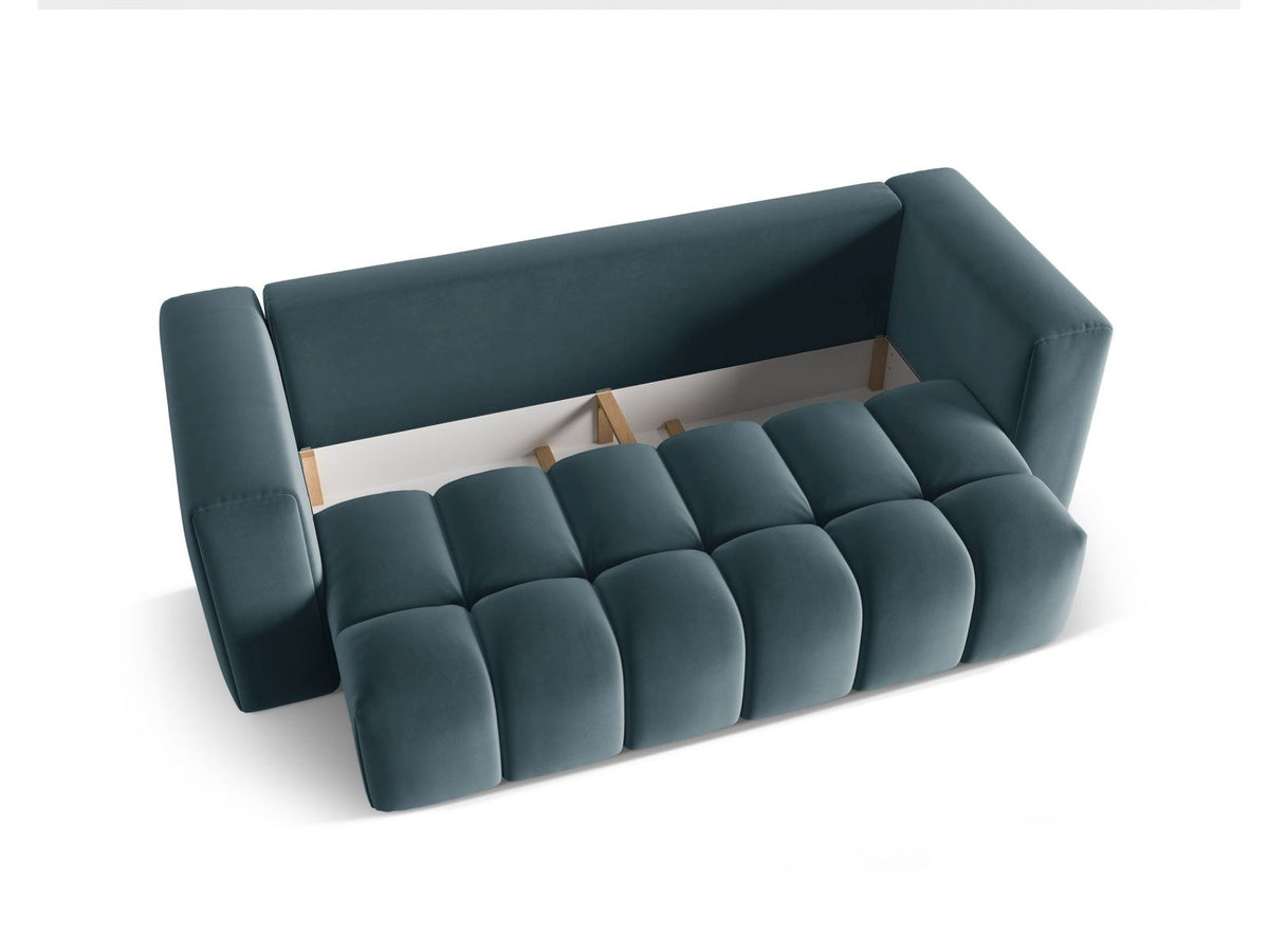 Sandfarbenes Samt-Bettsofa Verona mit drei Sitzplätzen, ausklappbarer Liegefläche, Bettkasten und schwarzen Kunststoffbeinen im Wohnraum.