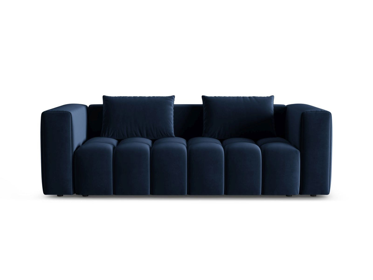 Sandfarbenes Samt-Bettsofa Verona mit drei Sitzplätzen, ausklappbarer Liegefläche, Bettkasten und schwarzen Kunststoffbeinen im Wohnraum.