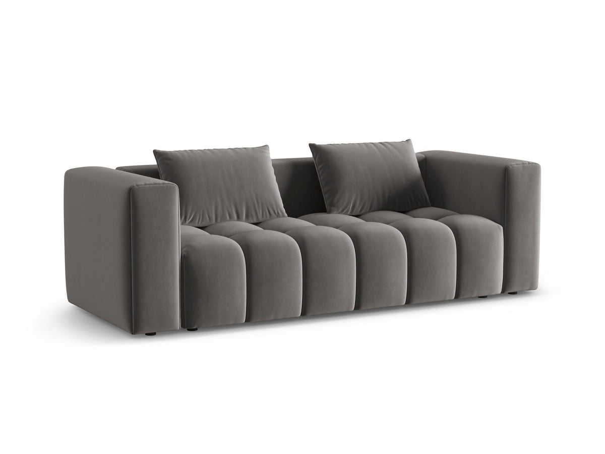 Sandfarbenes Samt-Bettsofa Verona mit drei Sitzplätzen, ausklappbarer Liegefläche, Bettkasten und schwarzen Kunststoffbeinen im Wohnraum.