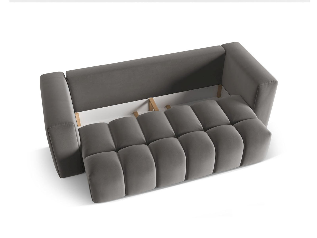 Sandfarbenes Samt-Bettsofa Verona mit drei Sitzplätzen, ausklappbarer Liegefläche, Bettkasten und schwarzen Kunststoffbeinen im Wohnraum.