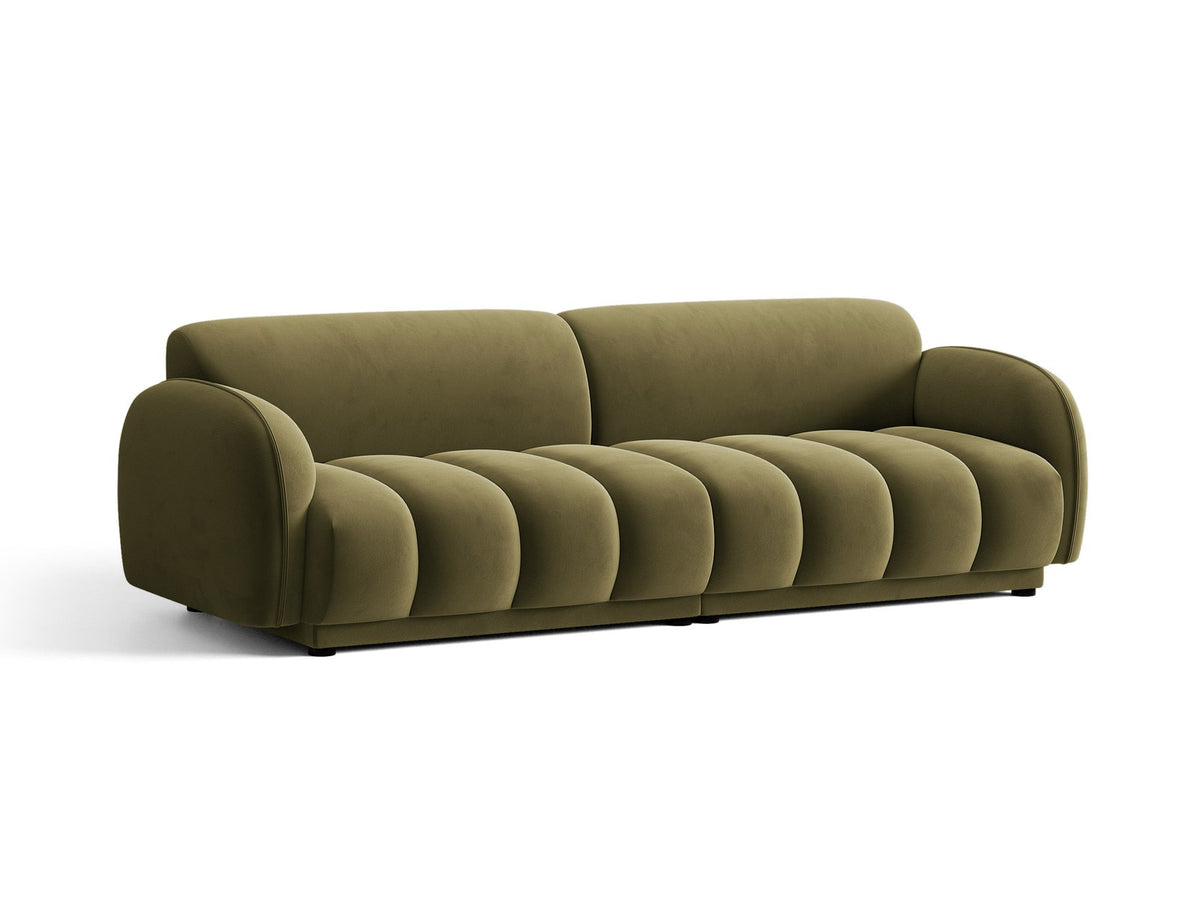 Vierersofa Bilbao mit hellbeigem Samtbezug, schwarzen Kunststoffbeinen und klarer, gerader Linienführung, fotografiert freistehend im Raum.