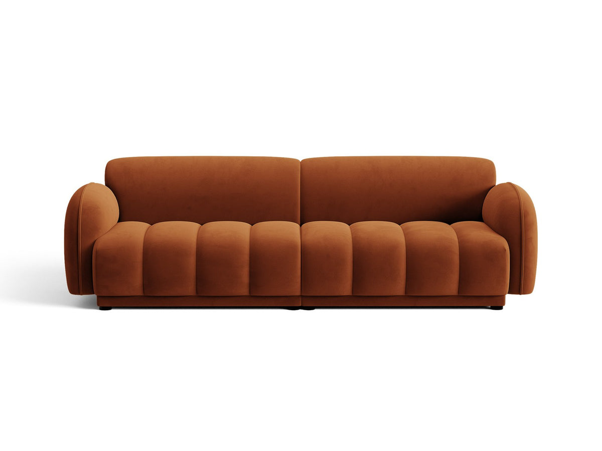 Vierersofa Bilbao mit hellbeigem Samtbezug, schwarzen Kunststoffbeinen und klarer, gerader Linienführung, fotografiert freistehend im Raum.
