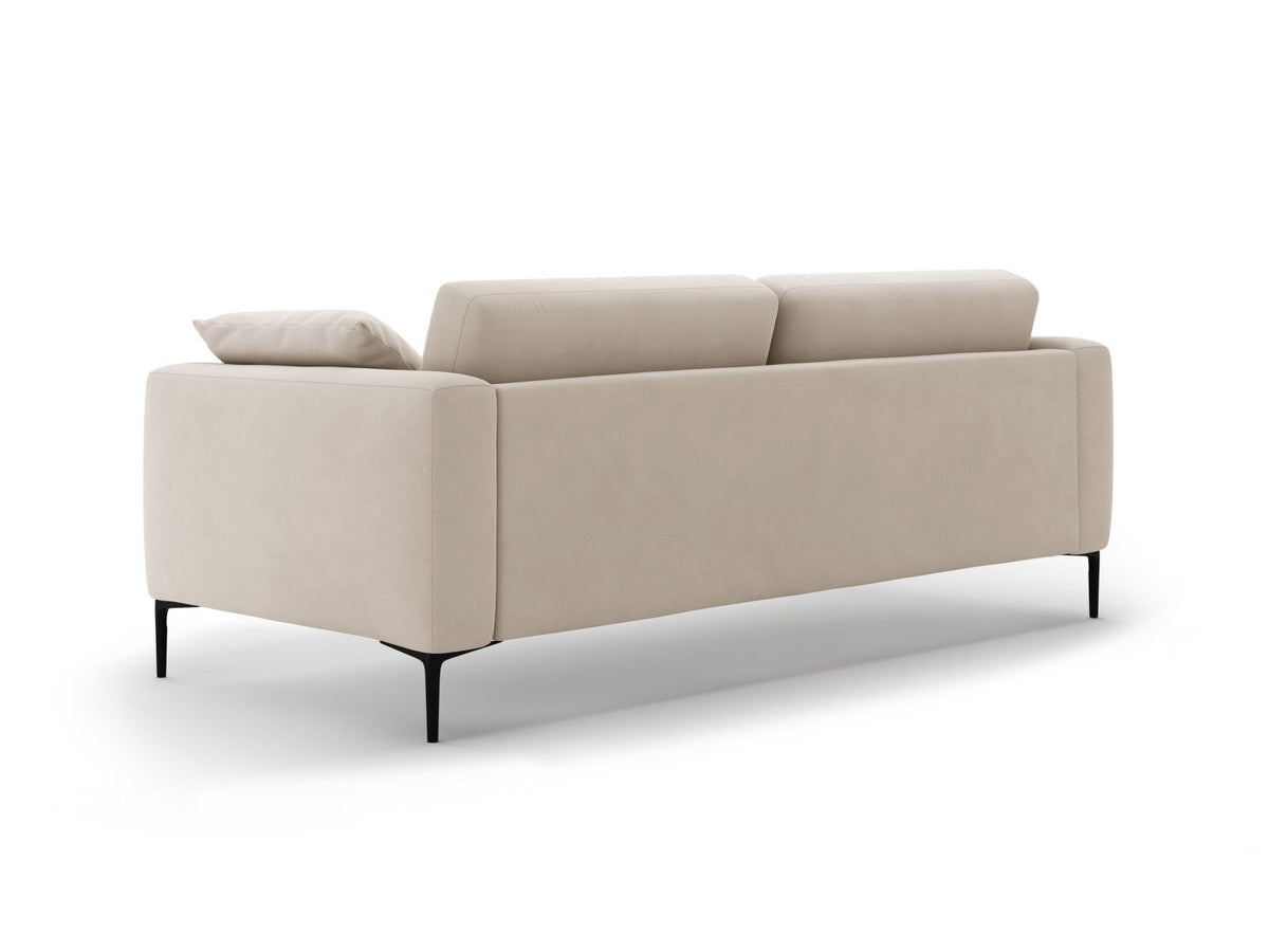 Beige Samt-Sofa Lazio mit 4 Sitzplätzen, Massivholzrahmen, Sitzpolster und schwarzen Metallbeinen, Frontalansicht im Wohnraum.