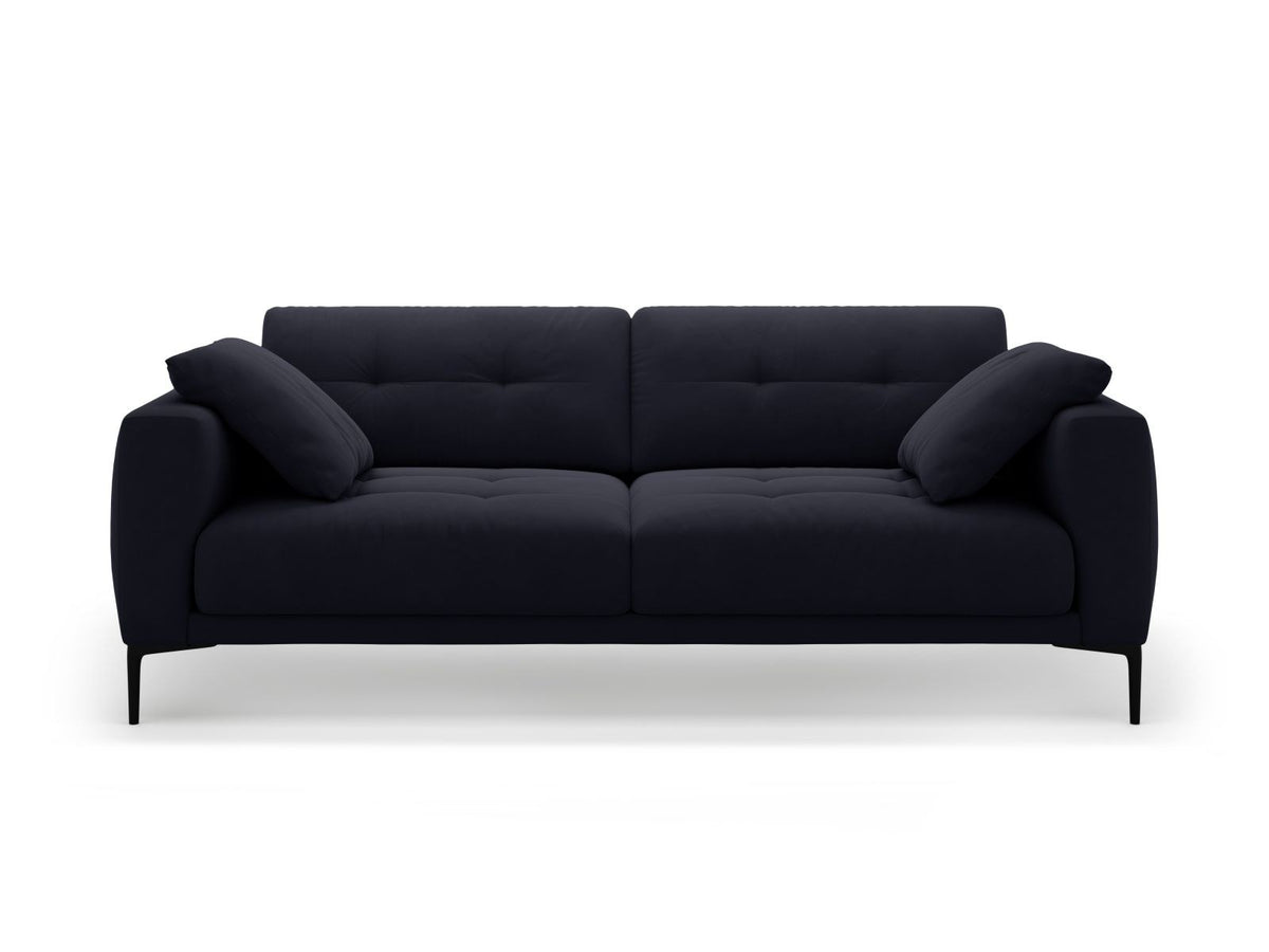 Beige Samt-Sofa Lazio mit 4 Sitzplätzen, Massivholzrahmen, Sitzpolster und schwarzen Metallbeinen, Frontalansicht im Wohnraum.