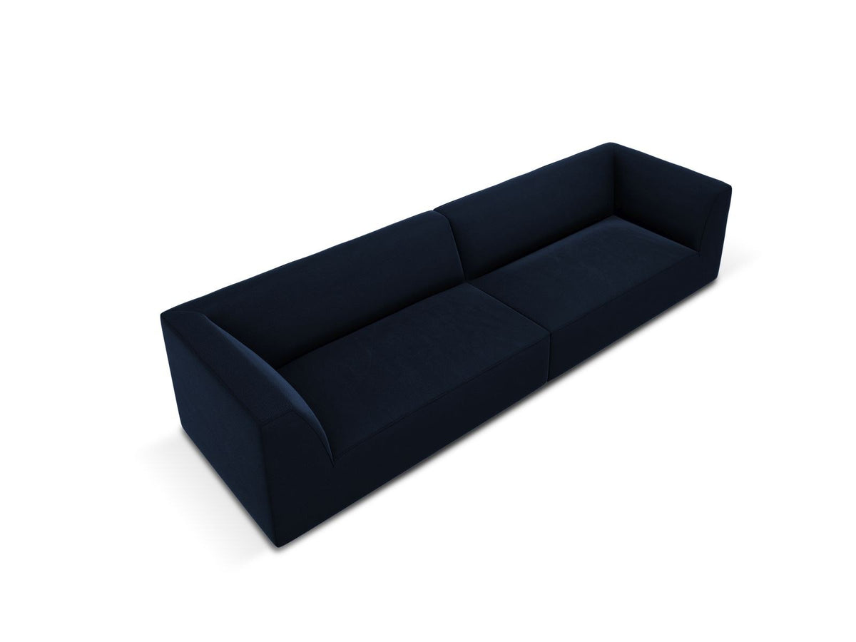 Beige-farbenes 4er Sofa Siena mit Samtbezug, schwarzen Kunststoffbeinen und gepolsterter Rückenlehne, Frontalansicht auf hellem Hintergrund.
