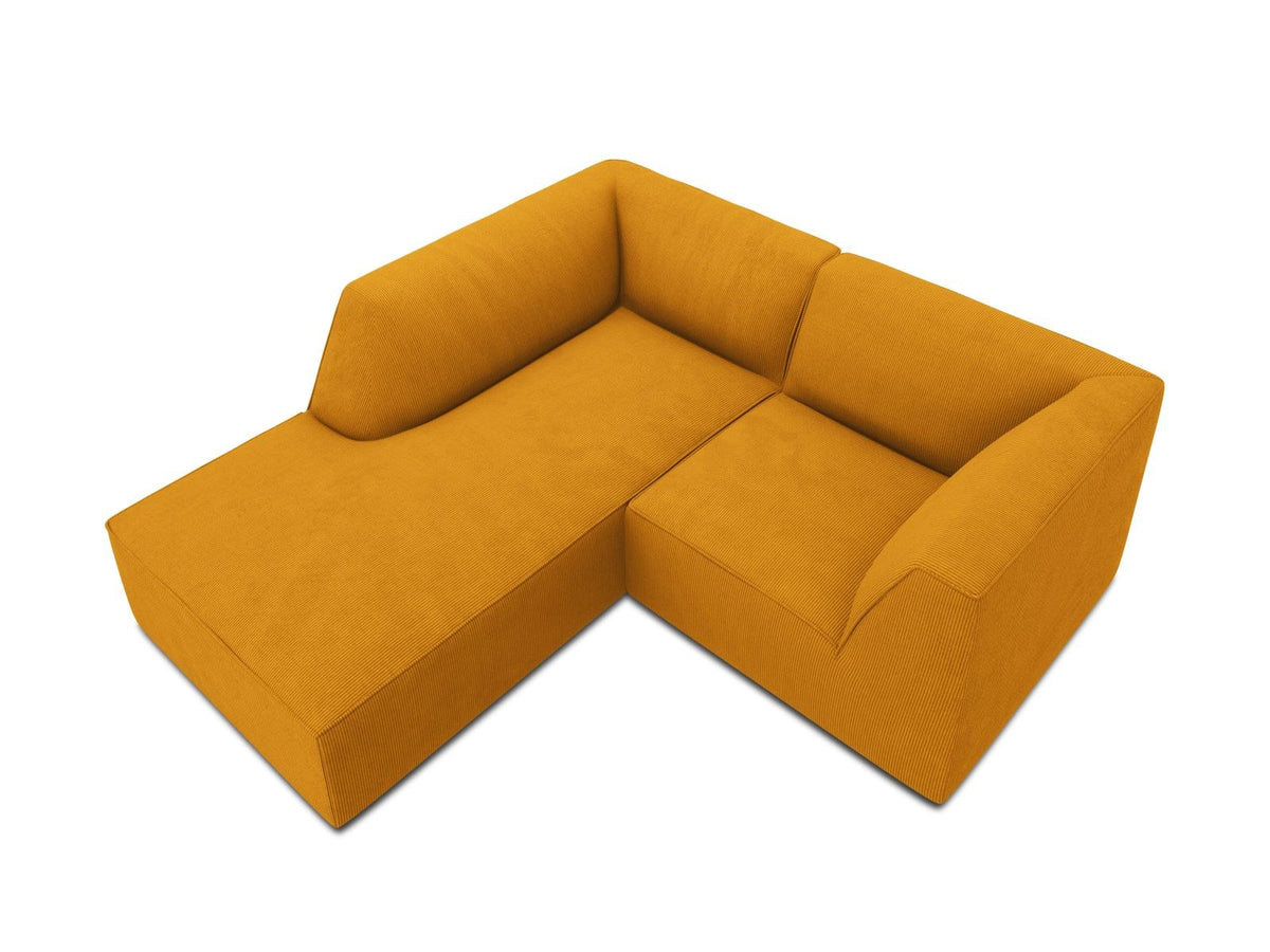 Modulares Ecksofa Siena mit gelbem Ottawa-Stoffbezug, schwarzen Kunststoffbeinen und Récamiere, Ansicht von vorne im Wohnraum.