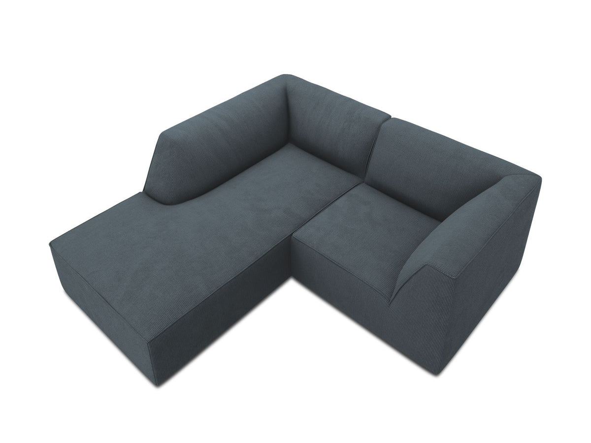 Modulares Ecksofa Siena mit gelbem Ottawa-Stoffbezug, schwarzen Kunststoffbeinen und Récamiere, Ansicht von vorne im Wohnraum.