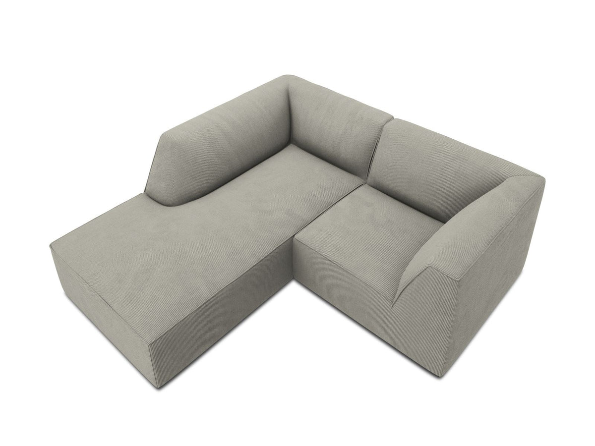 Modulares Ecksofa Siena mit gelbem Ottawa-Stoffbezug, schwarzen Kunststoffbeinen und Récamiere, Ansicht von vorne im Wohnraum.