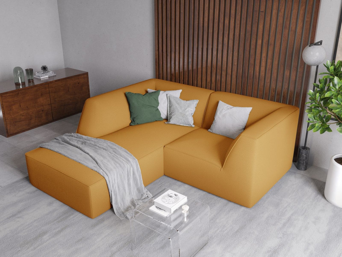 Modulares Ecksofa Siena mit gelbem Ottawa-Stoffbezug, schwarzen Kunststoffbeinen und Récamiere, Ansicht von vorne im Wohnraum.