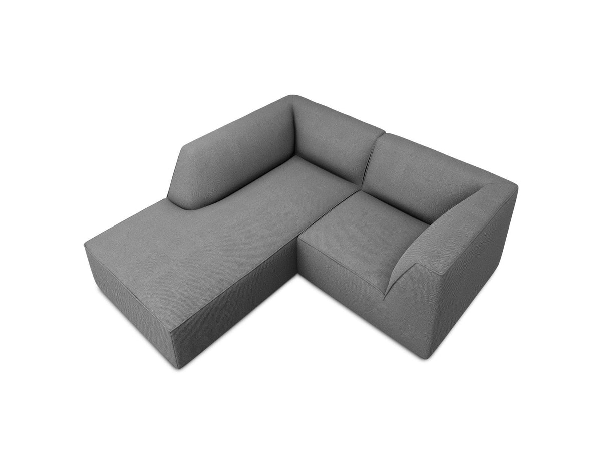 Modulares Ecksofa Siena mit gelbem Ottawa-Stoffbezug, schwarzen Kunststoffbeinen und Récamiere, Ansicht von vorne im Wohnraum.