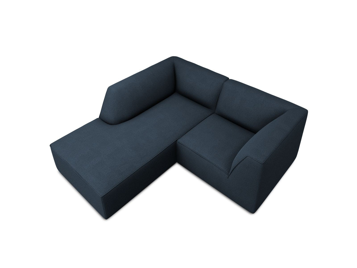 Modulares Ecksofa Siena mit gelbem Ottawa-Stoffbezug, schwarzen Kunststoffbeinen und Récamiere, Ansicht von vorne im Wohnraum.