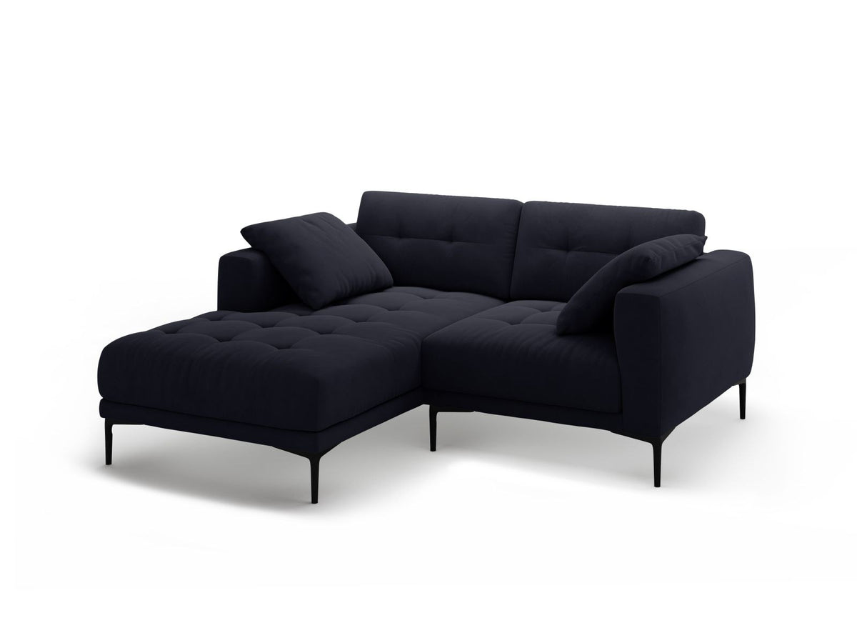 Beige-farbenes Samtsofa Lazio als 2-Sitzer Ecksofa links mit Récamiere, Massivholzrahmen und schwarzen Metallbeinen, Frontalansicht.