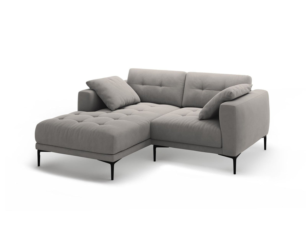 Beige-farbenes Samtsofa Lazio als 2-Sitzer Ecksofa links mit Récamiere, Massivholzrahmen und schwarzen Metallbeinen, Frontalansicht.