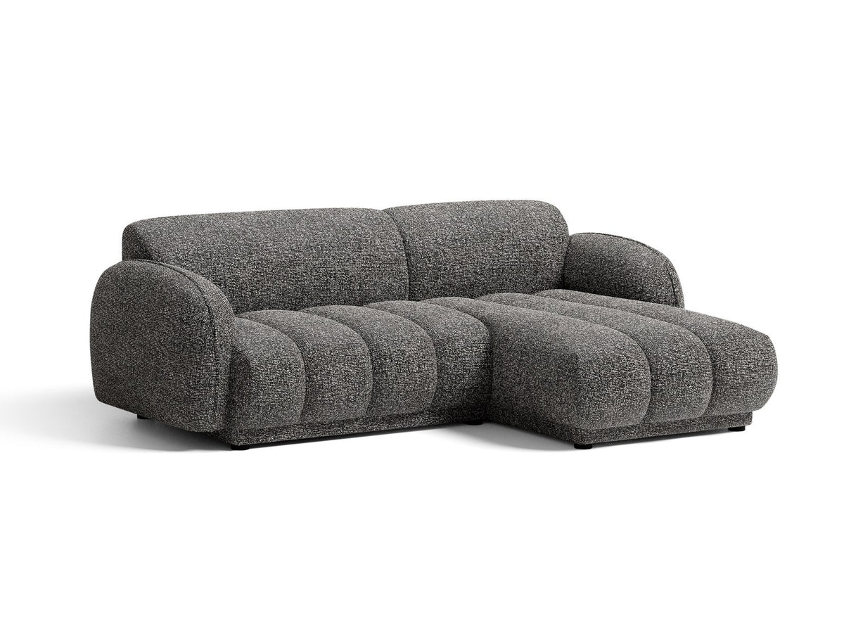 Beiges Ecksofa Bilbao mit Bouclé-Stoff Miles Sand, rechtsseitiger Récamiere, schwarzen Kunststoffbeinen und klarer, moderner Formgebung.