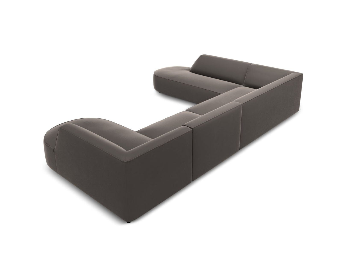 Panorama-Ecksofa links mit Samtbezug in Beige, massivem Holzrahmen und schwarzen Kunststoffbeinen, Modell Siena von Cosmopolitan Design.