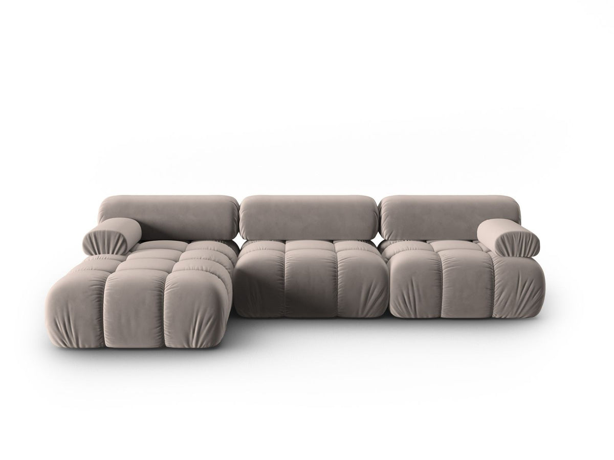 Modulares Ecksofa mit rosa Samtstoff, schwarzen Kunststoffbeinen und gepolsterter Récamiere, Ansicht von vorne links.