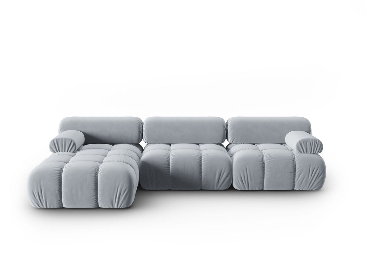 Modulares Ecksofa mit rosa Samtstoff, schwarzen Kunststoffbeinen und gepolsterter Récamiere, Ansicht von vorne links.