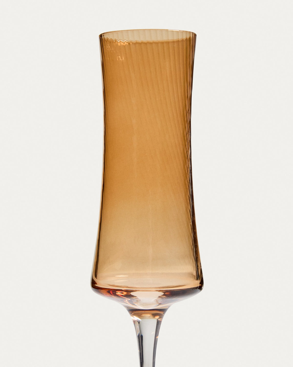 Hellorangefarbenes Sektglas aus Bernsteinglas mit dezentem Relief, schlanke Form, Fassungsvermögen 15 cl, Material 100% Glas.