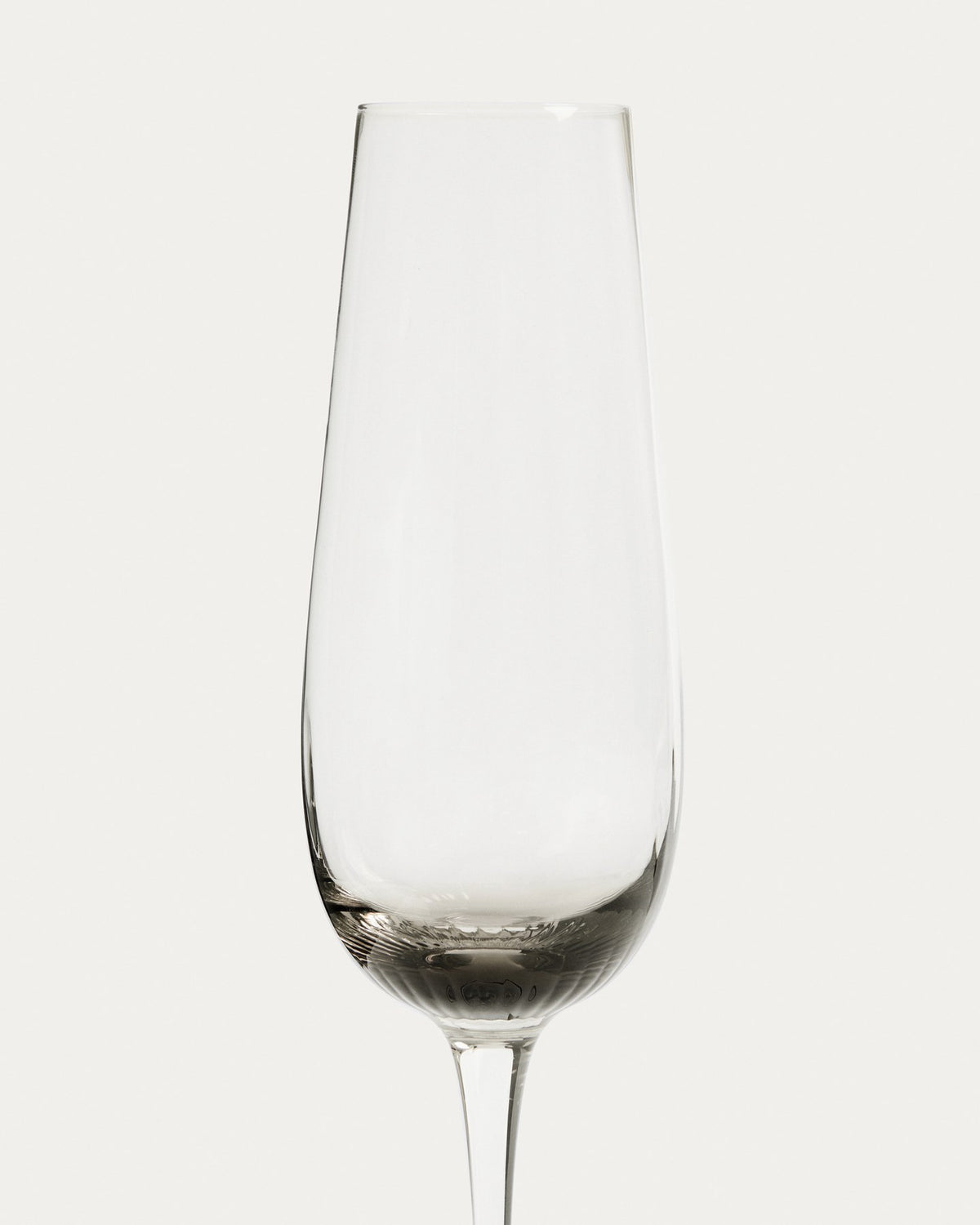 Sektglas Davel aus hellgrauem Glas mit abgerundetem Fuss und grauem Boden, Fassungsvermögen 21,5 cl, Höhe 27 cm.
