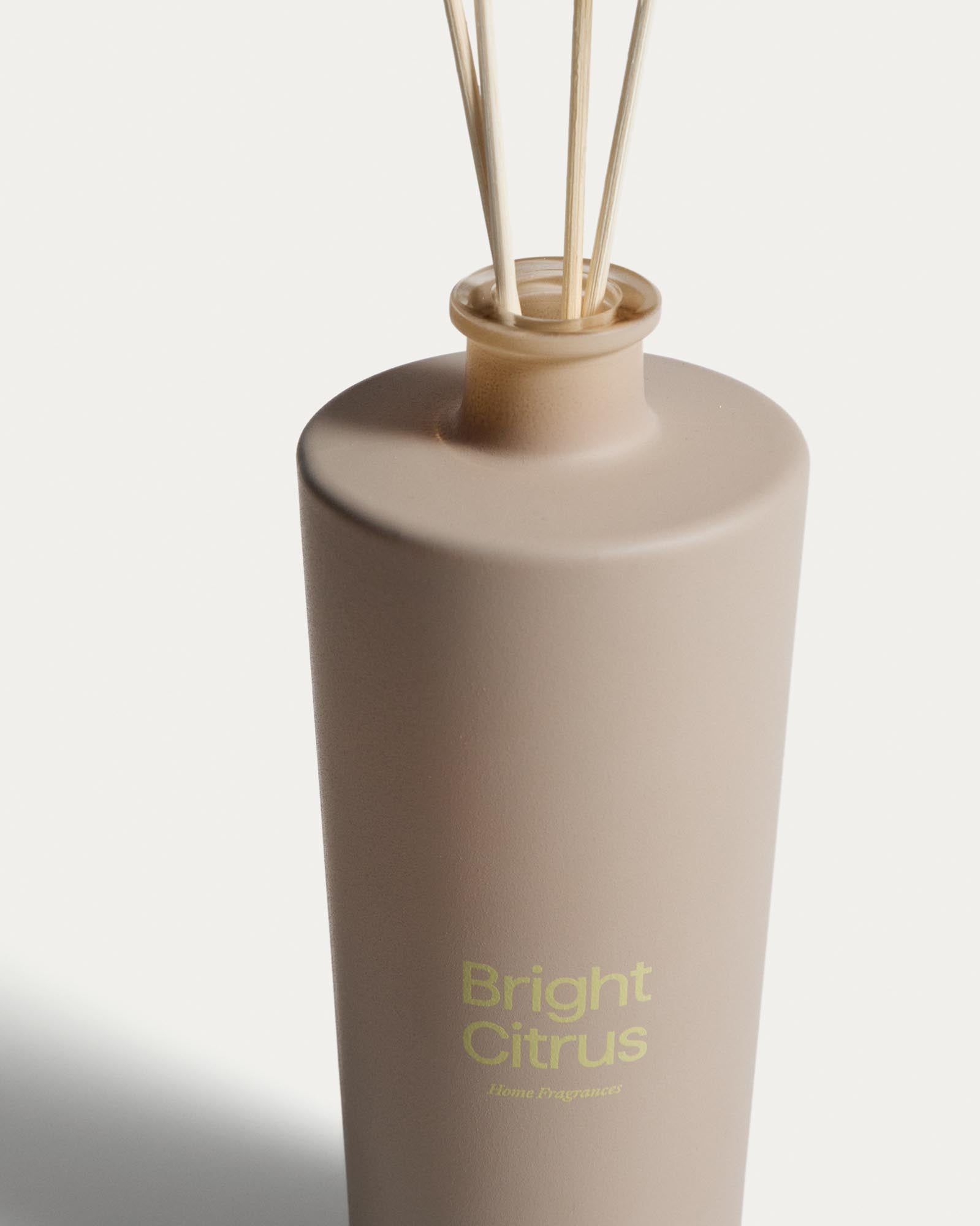 Beige Flasche mit Citronella-Lufterfrischer Bright Citrus von Kave Home, 500 ml, ausgestattet mit eleganten Duftstäbchen für erfrischenden Raumduft.