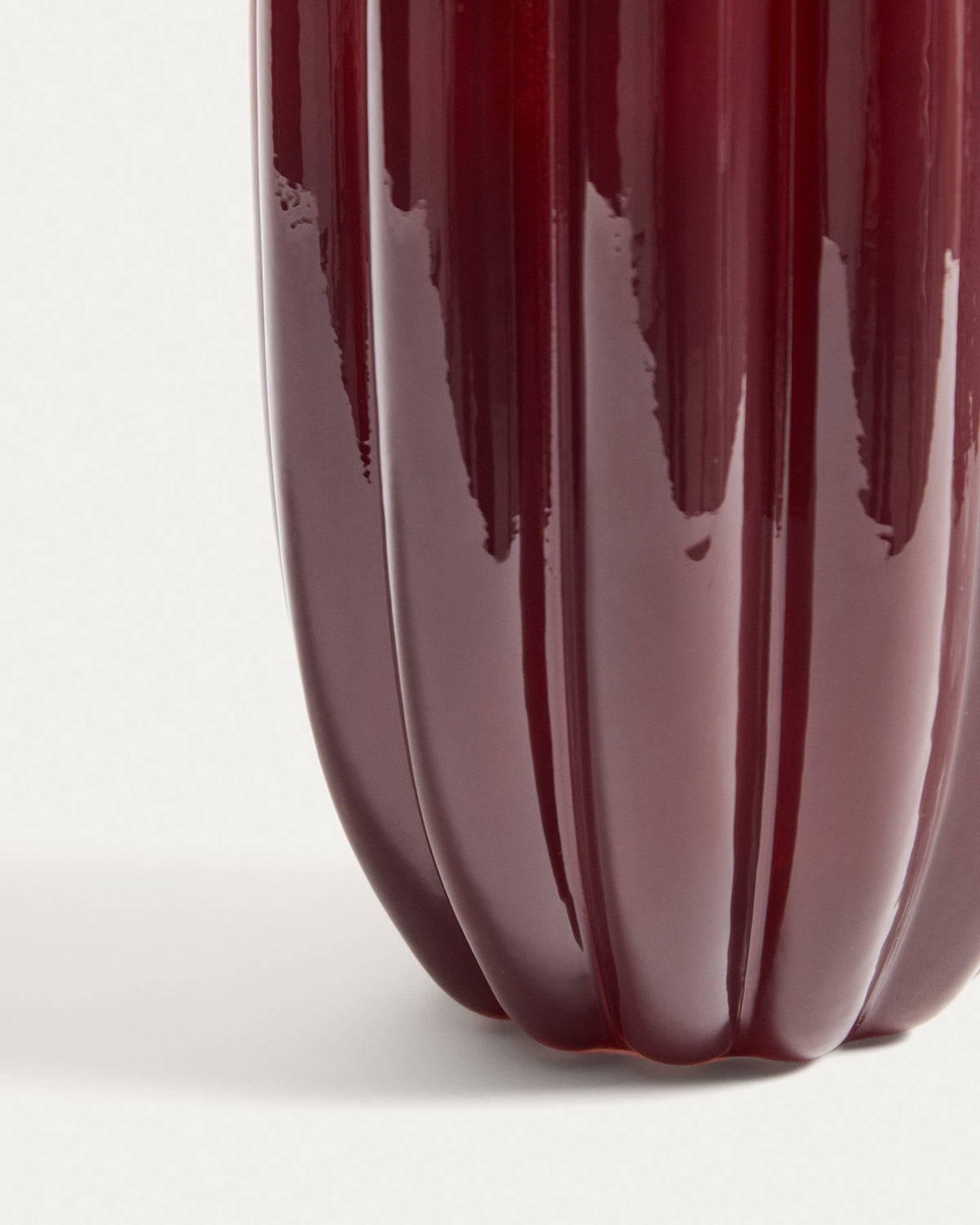 Burgunderrote Glas-Vase mit vertikalem Relief und rundem Öffnungsdurchmesser von 14,5 cm, Höhe 25 cm, aus durchgefärbtem Glas.