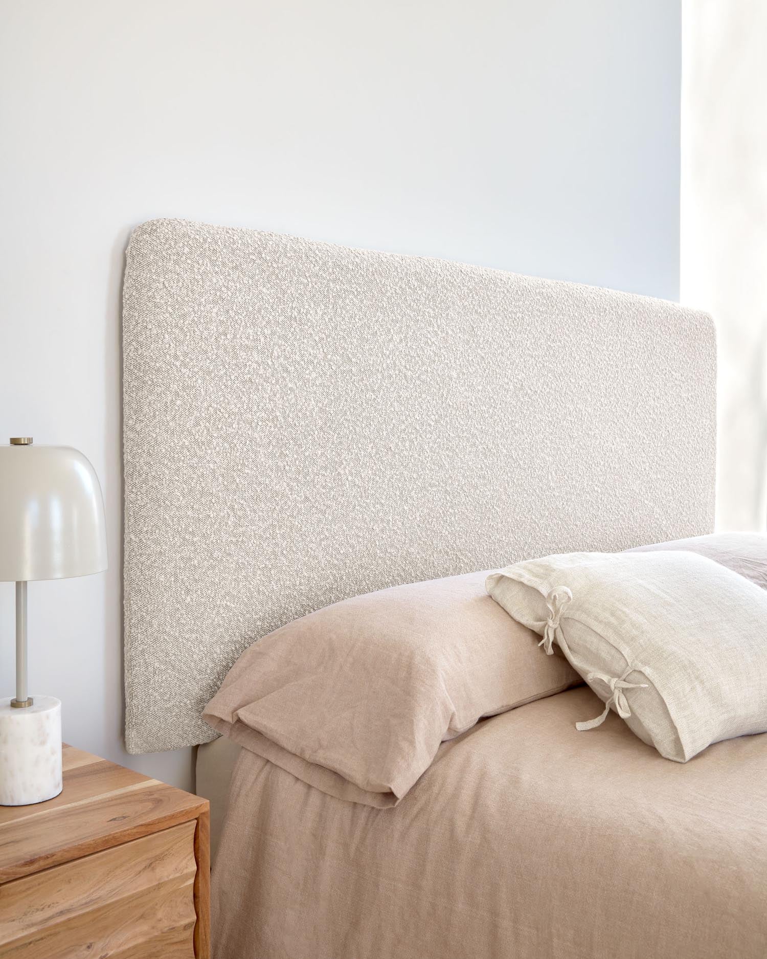 Das Dyla Bettkopfteil in stilvollem Bouclé Weiß kombiniert modernes Design mit Funktionalität. Perfekt für 160 cm Betten, nachhaltig und leicht zu reinigen.