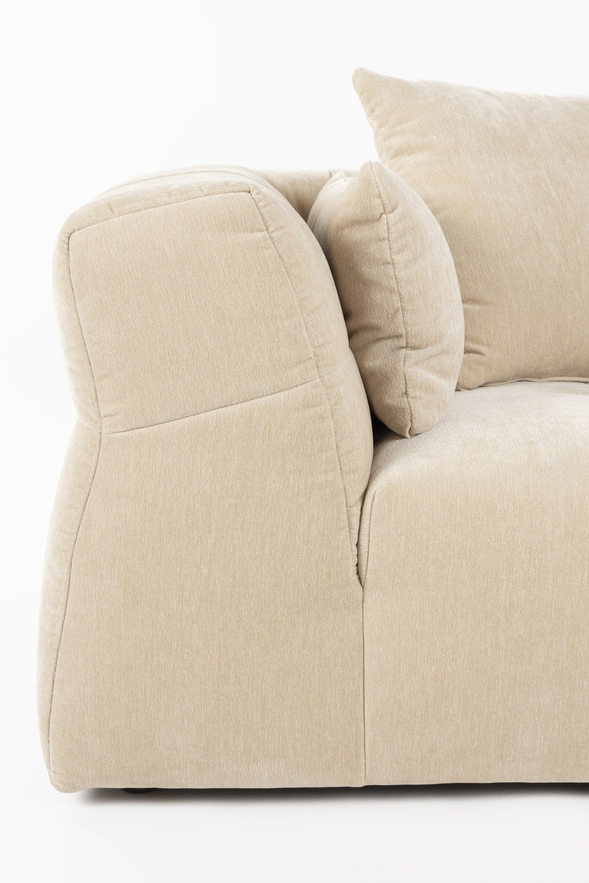 Beiges 5er Sofa Hodge von Dutchbone mit gestepptem Samtbezug, geschwungenen Armlehnen und leicht ausgestellten Rückenlehnen.