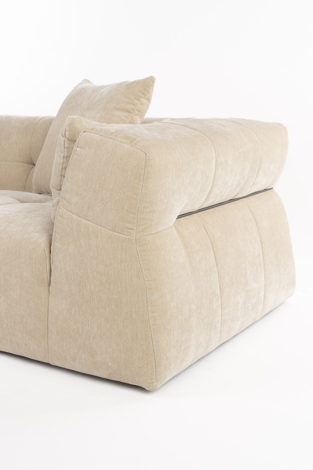 Beiges Ecksofa Hodge mit linksseitiger Chaiselongue, gesteppter Sitz- und Rückenlehne aus glänzendem Samtstoff, leicht nach aussen gebogene Armlehnen.