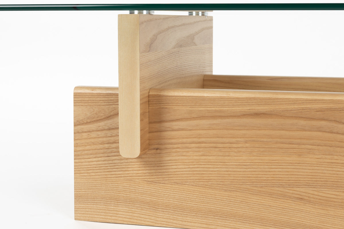 Couchtisch Lucifer Natural von Dutchbone mit Gestell aus zwei quer angeordneten Holzplatten und rechteckiger Tischplatte aus transparentem Glas.