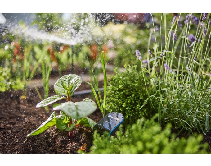 Schwarzer GARDENA Bodenfeuchtesensor Smart Sensor mit flachem Kopfteil und langem Fühler, freigestellt auf hellem Hintergrund fotografiert.